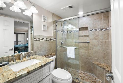 a bathroom with a shower and a toilet and a sink at Caprice Resort by Travel Resort Services in St. Pete Beach
