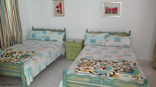 a bedroom with two beds and a dresser in it at Virginia beach village in El Alamein