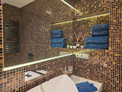 a bathroom with a sink and a mirror and blue towels at Vision Luxury Apartment Rynek in Wrocław