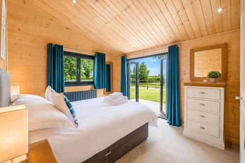a bedroom with a large bed with blue curtains at 2 Bed in Nafferton oc-o31954 in Nafferton