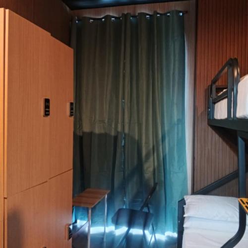 a bedroom with a bed and a window with a chair at Sanibelle Hotel in Coron