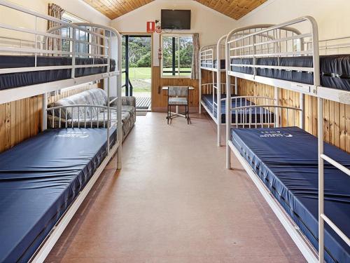 a room with several bunk beds in a school bus at BIG4 Ingenia Holidays Phillip Island in Newhaven
