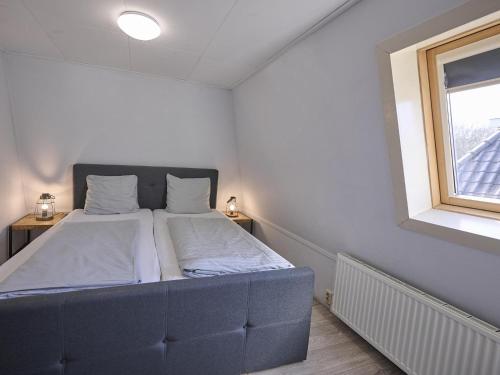 a bed in a small room with a window at t Kaatsheuveltje 1 in Kaatsheuvel