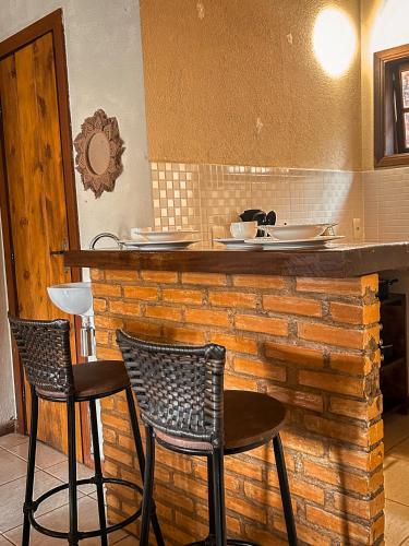 a bar with two chairs and a counter at Pousada Alto do Vale in Nova Friburgo