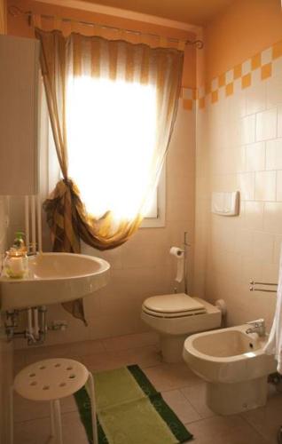 a bathroom with a sink and a toilet and a window at Zio Stefy in Cittadella
