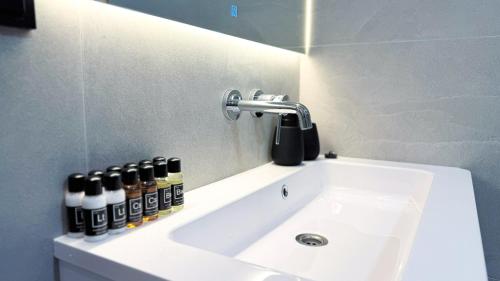 a bathroom sink with a mirror and bottles on it at Нова Дача in Kozintsy