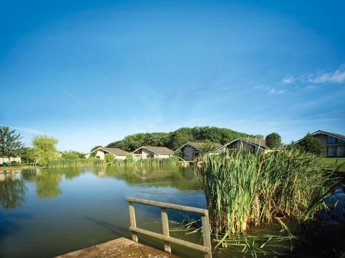 a body of water with houses in the background at The Motel, Ribby Hall Village in Wrea Green