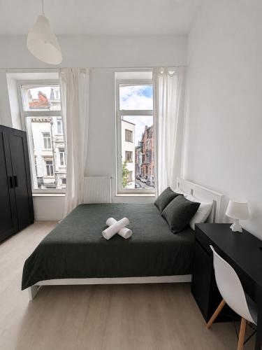 a bedroom with a bed with a teddy bear on it at Maison de Florence in Brussels