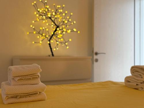 a group of towels on a bed with a tree with lights at Ottov Raj Na Dunavu in Krčedin