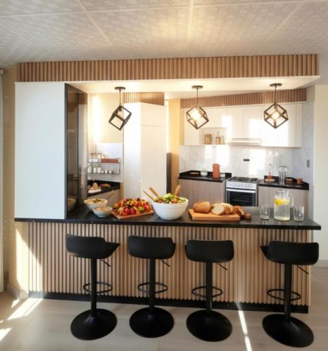 a kitchen with a counter with bar stools at APART SExTA ESTACIÓN in Juliaca