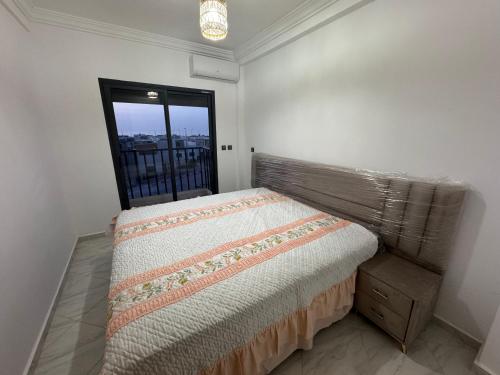 a small bedroom with a bed and a window at Alhoceima - vue sur la mer- Green village2 in Al Hoceïma