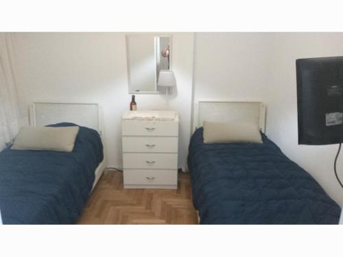 a bedroom with two beds and a white dresser at Pacor in Mar del Plata