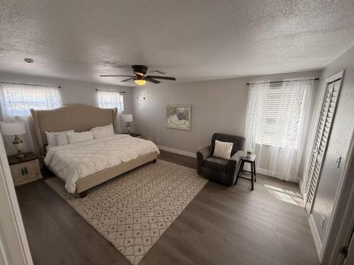 a bedroom with a bed and a chair and windows at my place to be in Port Charlotte