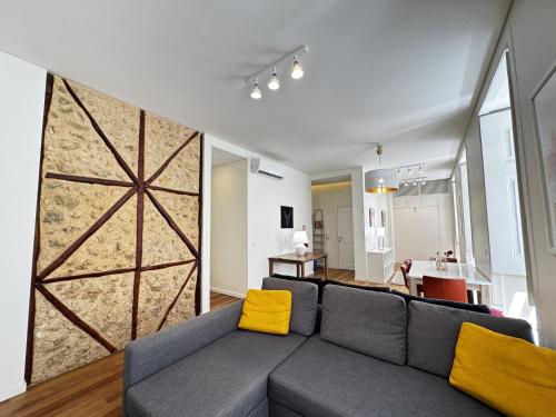 a living room with a gray couch with yellow pillows at Lux Old Town in Lisbon