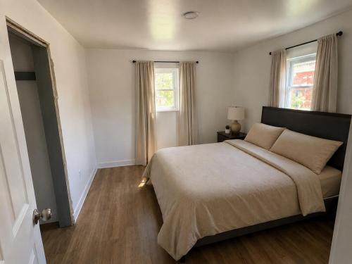 a bedroom with a large bed and two windows at Homestead Bungalow in Dayton