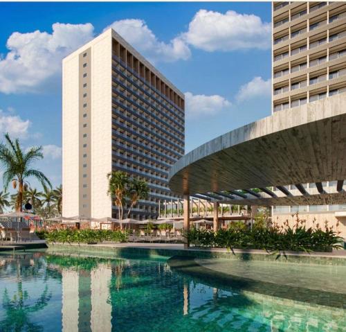 a building and a swimming pool in front of a building at Apartamento no Beach Resort Salinas in Ilha de Atalaia