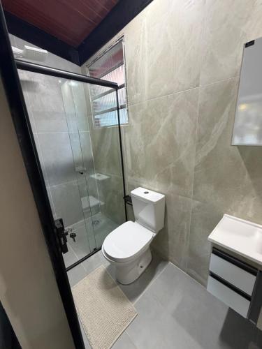 a bathroom with a shower and a toilet and a sink at Vila do Tênis in Guaratinguetá