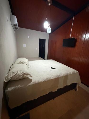 a bedroom with a large bed with a wooden wall at Vila do Tênis in Guaratinguetá