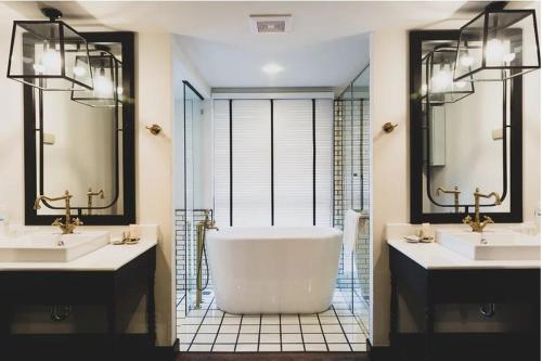 ein Badezimmer mit zwei Waschbecken und einer Badewanne in der Unterkunft MORA Boutique Hotel in Chiang Rai