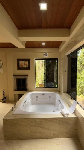 a large bathroom with a large bath tub at Green Valley Hydro Suite - Monte Verde-MG in Camanducaia