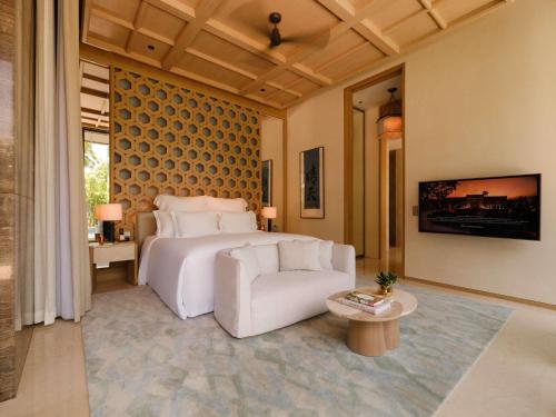 a bedroom with a bed and a couch and a table at Raffles Sentosa Singapore in Singapore