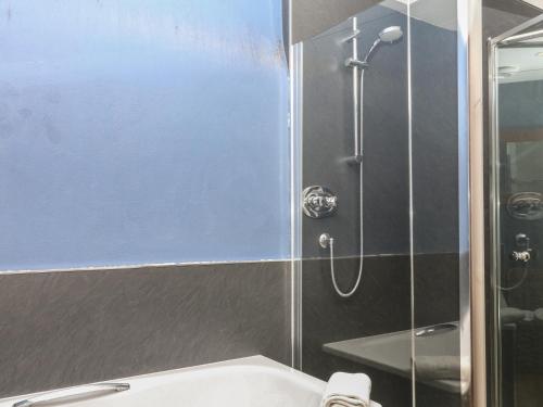 a shower with a glass door next to a sink at Mixit Cottage in Kingsbridge