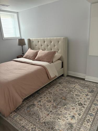 a bedroom with a bed with a headboard and a rug at The Basement apartment in Milton