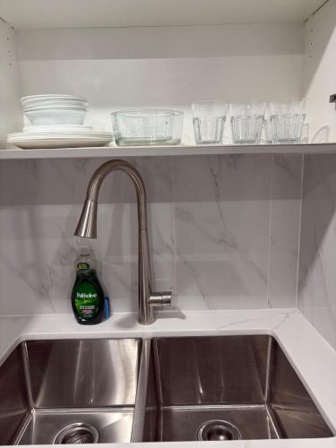 a kitchen sink with a bottle of dish soap at The Basement apartment in Milton