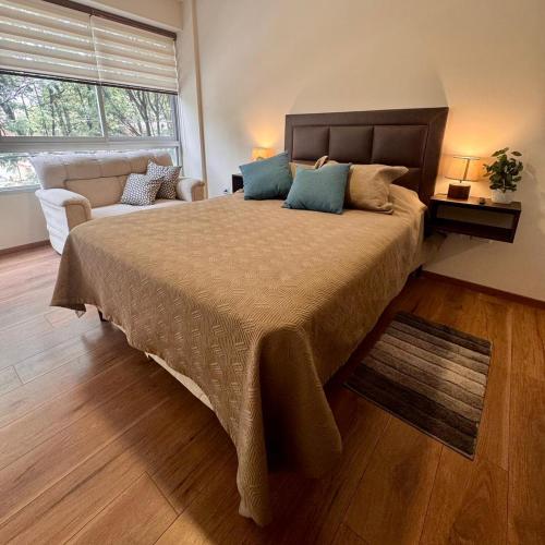 a bedroom with a large bed and a couch at Depar 1 Dormitorio B in Cochabamba