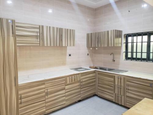 a kitchen with wooden cabinets and a sink at Residence Emilienne in Cotonou