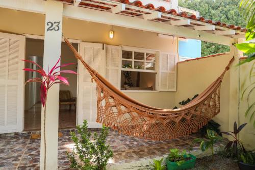 a hammock hanging from the side of a house at Casa Laguna - Geribá in Búzios