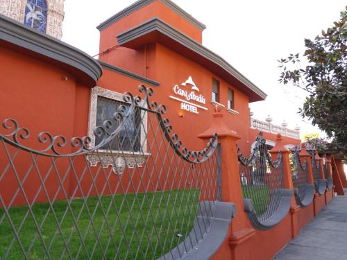 an orange building with a fence in front of it at Hotel Boutique Abad in Guadalajara