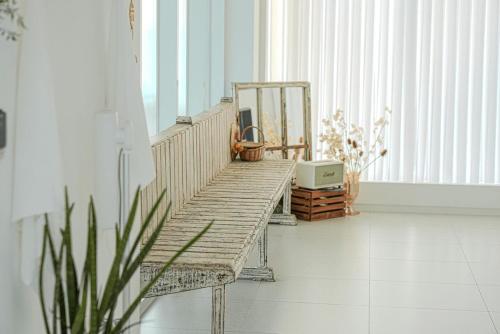 a wooden bench sitting in a room with a window at Seesun Art Studio Villa in Ansan