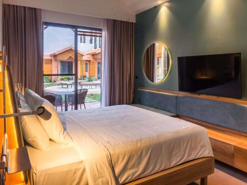 a bedroom with a large bed and a large window at NOVOTEL KOLWEZI in Kolwezi