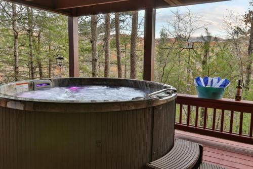 a large hot tub on a deck with a view of trees at Living on the Ledge - Long-Range Mountain Views - Hot Tub and Fire Pit in Blue Ridge
