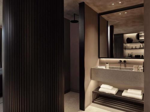 a bathroom with a sink and a mirror at Nirema Hotel & Spa Samos - MGallery Collection in Samos