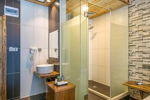a bathroom with a glass shower and a sink at 莫干山后舍民宿 in Deqing