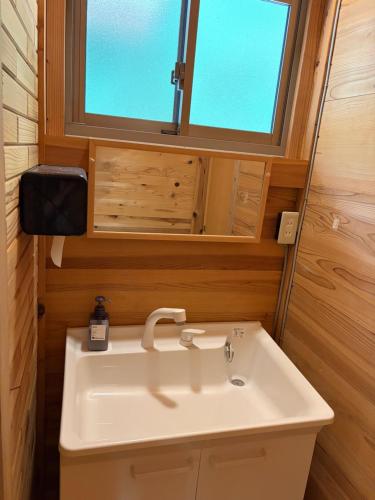 a bathroom with a white sink and a window at YAMAYA BASE 1 in Ōkawamochi