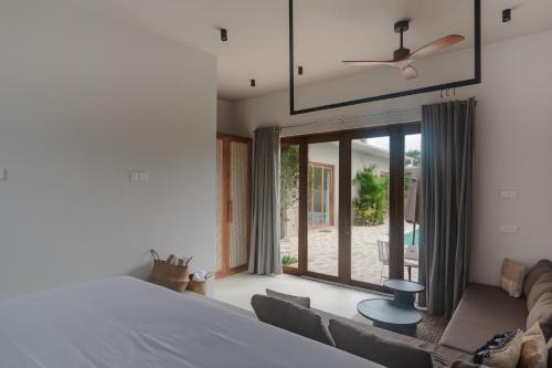 a bedroom with a bed and a couch at Tayo Villa in Ahangama