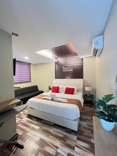 a bedroom with a large white bed with red pillows at TC Maya Abaya Hotel in Kuantan