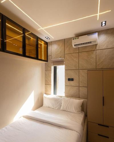 a bedroom with a white bed and a window at Tiny Studio Apartment with Pool and gym in Lekki