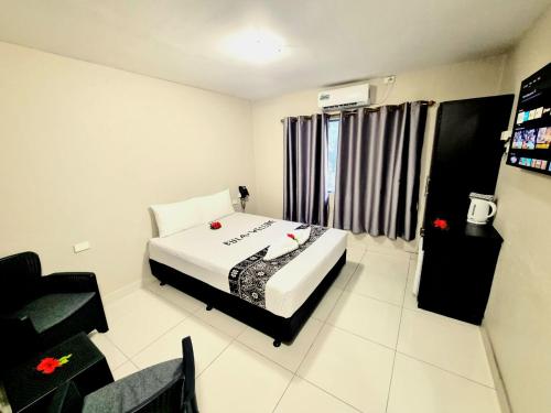 a bedroom with a bed and a television in it at Red Palm Hotel in Suva
