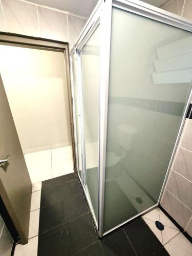 a shower with a glass door in a bathroom at Red Palm Hotel in Suva