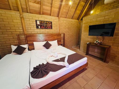 a bedroom with a large bed with a flat screen tv at Deduru Oya Cinnamon Gardens in Barandara