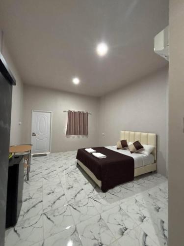 a bedroom with a bed and a marble floor at MWELL House in Ban Klang