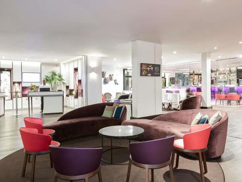 a living room with two couches and a table and chairs at Novotel Abidjan Plateau in Abidjan