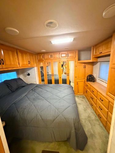 a bedroom with a bed and wooden cabinets at comfortable home on wheels in Gadsden