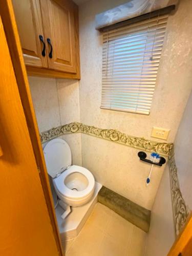 a small bathroom with a toilet and a window at comfortable home on wheels in Gadsden
