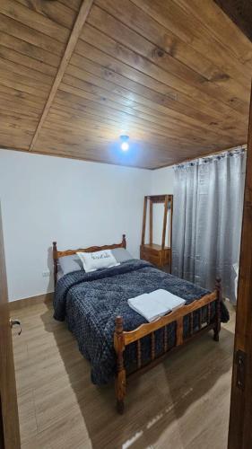 a bedroom with a bed with a wooden ceiling at Hospedaje J & L 2 in Uspallata