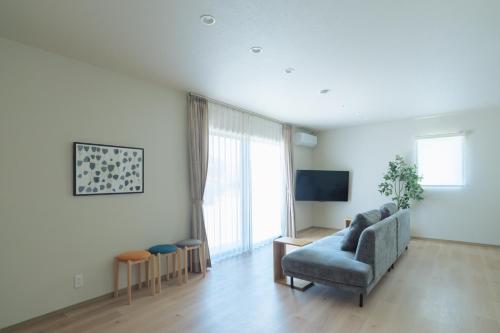 a living room with a couch and a tv at Green Peak 1 in Aso